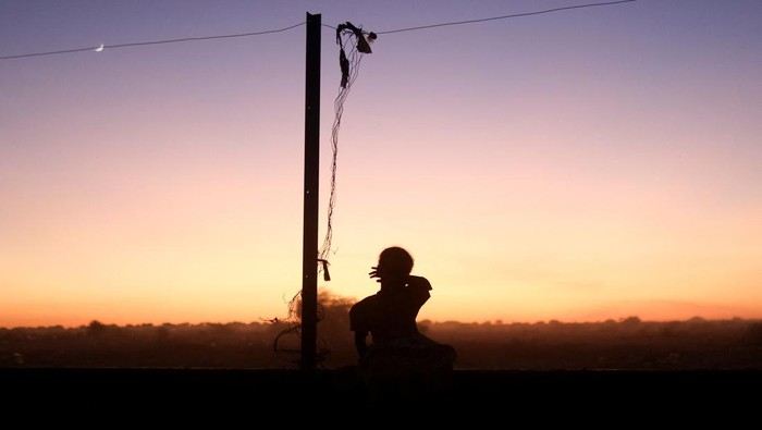 Di tengah keterbatasan bantuan dan padatnya Kamp Transit, pemandangan matahari terbenam menjadi satu-satunya jeda harian bagi para keluarga yang melarikan diri. REUTERS/Amr Abdallah Dalsh
