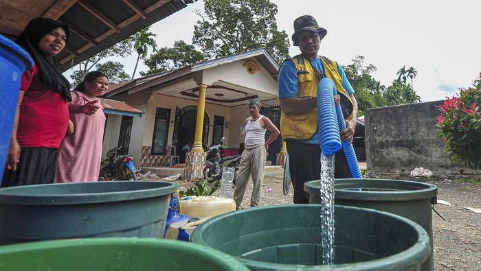 Pekerja mengisi ember warga saat penyaluran air bersih untuk korban banjir bandang di Jorong Kayu Pasak Timur, Nagari Salareh Aia, Palembayan, Agam, Sumatera Barat, Rabu (3/12/2025). Pemberian layanan air bersih oleh Kementerian Pekerjaan Umum tersebut guna memenuhi kebutuhan air warga yang sejak Kamis (27/11) atau saat kejadian bencana tidak memiliki air bersih karena matinya aliran listrik dan rusaknya sejumlah sumur. ANTARA FOTO/Wahdi Septiawan/nz.