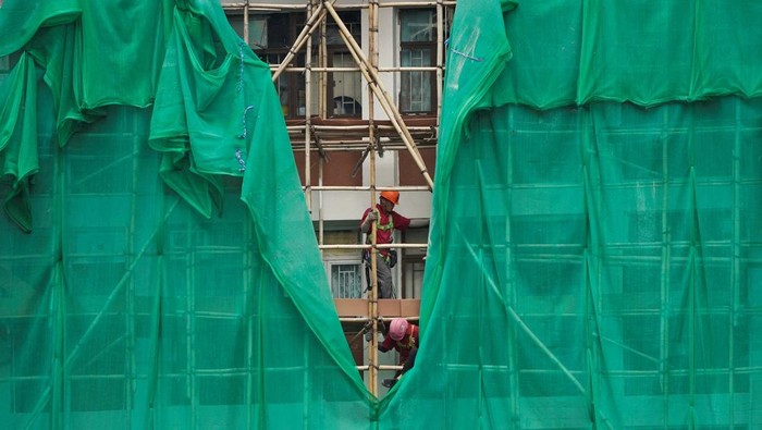 Workers remove scaffolding mesh from a building at Sui Wo Court in Sha Tin, following authorities' decision to remove the netting amid investigations into a deadly fire at Wang Fuk Court, in Hong Kong, China December 4, 2025. REUTERS/Vernon Yuen     TPX IMAGES OF THE DAY