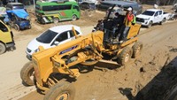 Sejumlah alat berat dikerahkan untuk mempercepat proses normalisasi. Excavator dan loader bergerak bolak-balik mengangkut lumpur yang mengeras, sementara petugas lain menyiram permukaan jalan untuk mengurangi licin dan memudahkan pembersihan. Aktivitas pembersihan berlangsung sejak pagi hari demi memulihkan akses transportasi yang sempat tersendat. ANTARA FOTO/Syifa Yulinnas
