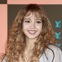 Rambut blonde-nya ditata keriting bervolume dengan soft bangs yang membingkai wajah, menghasilkan tampilan playful sekaligus girlie. Sementara itu, riasan wajah dibuat lembut dan glowing dengan bulu mata panjang nan lentik. Bibir diberi sentuhan lip gloss yang memberi kesan segar. Foto: ImaZins via Getty Images/The Chosunilbo JNS