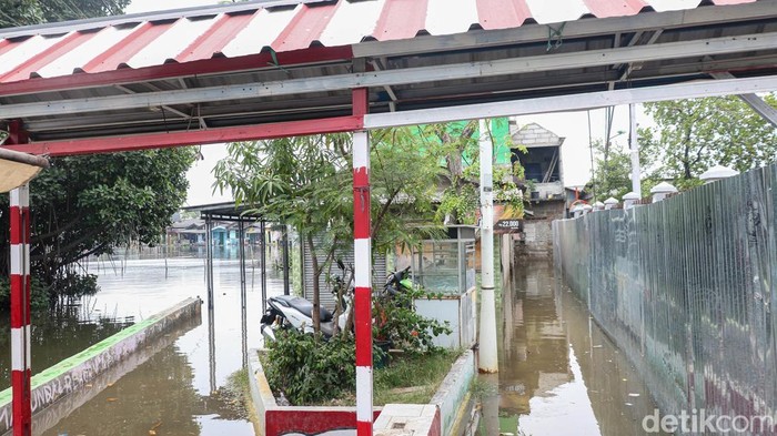 Banjir rob menutup akses jalan di kawasan Marunda Pulo, Jakarta Utara, Kamis (4/12/2025), menghambat mobilitas warga dan aktivitas harian di permukiman pesisir tersebut.