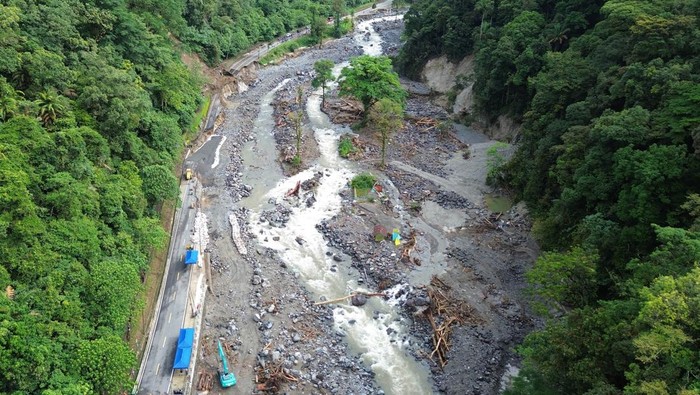 Pekerja mengoperasikan alat berat dalam penanganan jalan putus akibat banjir bandang di kawasan Mega Mendung, Lembah Anai, Tanah Datar, Sumatera Barat, Kamis (4/12/2025). Balai Pelaksanaan Jalan Nasional (BPJN) Sumatera Barat memprioritaskan penanganan darurat jalan putus tersebut dan menargetkan membuka kembali jalur bagi kendaraan ringan dalam waktu maksimal dua minggu. ANTARA FOTO/Iggoy el Fitra