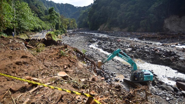 Pekerja mengoperasikan alat berat dalam penanganan jalan putus akibat banjir bandang di kawasan Mega Mendung, Lembah Anai, Tanah Datar, Sumatera Barat, Kamis (4/12/2025). Balai Pelaksanaan Jalan Nasional (BPJN) Sumatera Barat memprioritaskan penanganan darurat jalan putus tersebut dan menargetkan membuka kembali jalur bagi kendaraan ringan dalam waktu maksimal dua minggu. ANTARA FOTO/Iggoy el Fitra