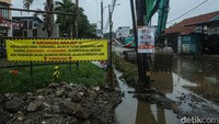 Petugas menggunakan alat berat mengerjakan proyek jalan dan drainase di Jalan PU, Cimuning, Kota Bekasi, Kamis (4/12/2025). 