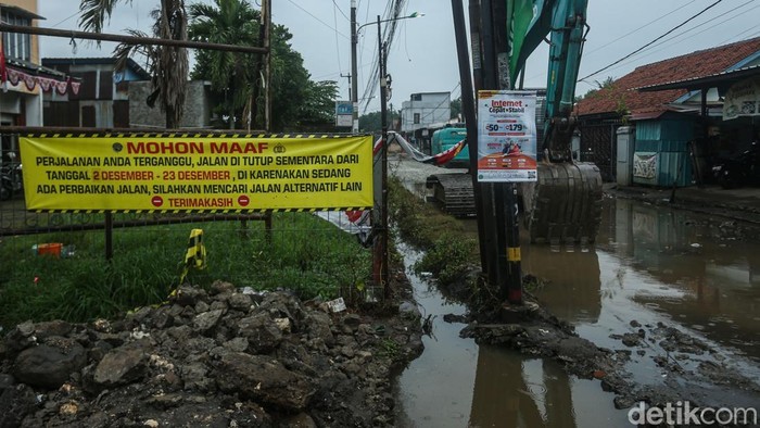 Petugas menggunakan alat berat mengerjakan proyek jalan dan drainase di Jalan PU, Cimuning, Kota Bekasi, Kamis (4/12/2025).