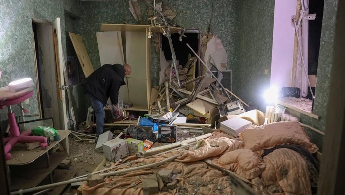 A resident collects things in his flat in an apartment building damaged by a Russian air strike, amid Russia's attack on Ukraine, in Sloviansk, Ukraine, December 3, 2025. REUTERS/Anatolii Stepanov