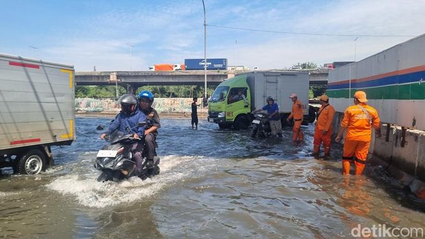 Banjir luapan air laut (rob) masih menggenangi kawasan Jakarta International Stadium (JIS) di Jakut. Sejumlah motor mogok saat menerobos genangan rob. (Taufiq/detikcom)