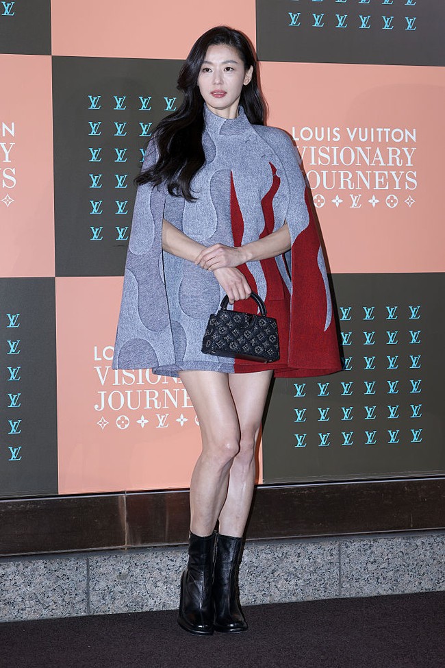 Beranjak ke para aktor dan aktris papan atas, Jun Ji Hyun terlihat begitu anggun dalam gaun bernuansa abu-abu dan merah, dilengkapi boots serta tas hitam. Rambutnya yang terurai terasa timeless dan classy. Foto: Getty Images
