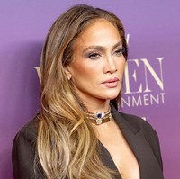 Meski bagian rok tampak rapi dan formal, blazernya justru hadir dengan potongan leher sangat rendah dan kerah draped shawl yang dramatis, menonjolkan gaya khas pelantun Get Right yang penuh kepercayaan diri. (Foto: Emma McIntyre/FilmMagic)