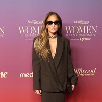 J.Lo, demikian ia lebih dikenal, mengenakan setelan berwarna cokelat tua rancangan Harith Hashim, terdiri dari blazer dan rok pensil sepanjang betis. (Foto: Monica Schipper/WireImage)