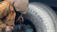 Dengan wearpack penuh oli dan tangan yang cekatan memegang velg, perempuan 35 tahun itu terus bekerja meski jelas rasa lelah menempel di wajahnya.