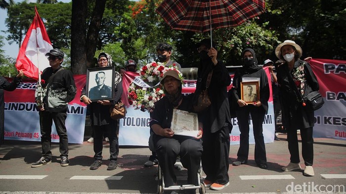 Sejumlah warga Putra-putri Pejuang 45 melakukan aksi unjuk rasa di Jl Medan Merdeka Selatan,Jakarta, Jumat (5/12/2025). Mereka menolak penggusuran rumah yang sudah ditempati selama puluhan tahun oleh putra-putri pejuang kemerdekaan 1945 di rumah ksatrian Berlan, Jakarta Timur. Dalam aksinya mereka membawa foto keluarga, sertifikat gelar pahlawan, karangan bunga, batu nisan hingga spanduk tuntutan. Aksi berlangsung tertib.