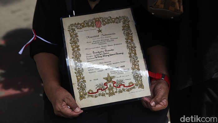 Sejumlah warga Putra-putri Pejuang 45 melakukan aksi unjuk rasa di Jl Medan Merdeka Selatan,Jakarta, Jumat (5/12/2025). Mereka menolak penggusuran rumah yang sudah ditempati selama puluhan tahun oleh putra-putri pejuang kemerdekaan 1945 di rumah ksatrian Berlan, Jakarta Timur. Dalam aksinya mereka membawa foto keluarga, sertifikat gelar pahlawan, karangan bunga, batu nisan hingga spanduk tuntutan. Aksi berlangsung tertib.