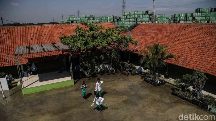 Sejumlah murid pulang sekolah saat banjir rob di kawasan MI EL Nur Kasysyaf, Kampung Bidara, Marunda, Jakarta Utara, Jumat (5/12/2025). Banjir rob yang mulai terjadi sejak kemarin ini mencapai puncaknya hari ini, dipicu oleh air pasang laut yang terus meningkat.