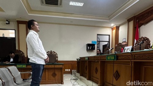 I Wayan Sudiarta saat berdiri mendengarkan vonis dari hakim Pengadilan Tipikor Denpasar, Jumat (5/12/2025).