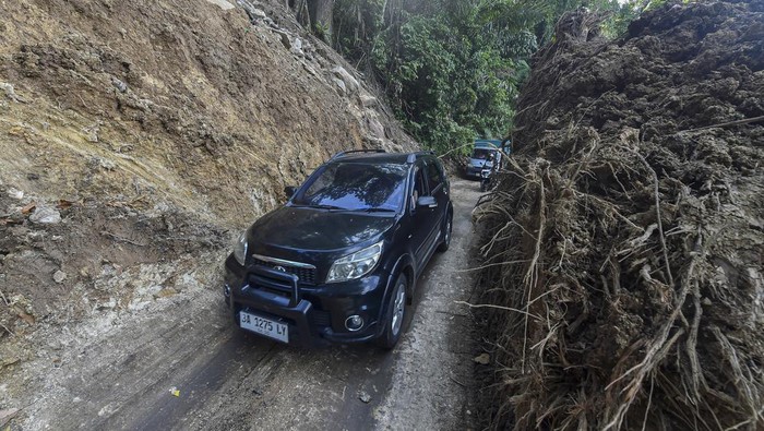 Pengendara sepeda motor melewati jalan bekas longsor yang telah dibersihkan di Kelok 44, Maninjau, Agam, Sumatera Barat, Sabtu (6/12/2025). Akses jalan darat dari Agam menuju Bukittinggi via Kelok 44 dan sebaliknya yang sempat tertimbun longsor sejak Rabu (26/11) kini telah berangsur normal dan bisa dilalui maksimal kendaraan roda empat setelah pemerintah daerah setempat menurunkan alat berat. ANTARA FOTO/Wahdi Septiawan/nym.