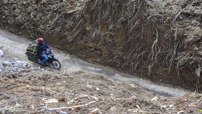 Pengendara sepeda motor melewati jalan bekas longsor yang telah dibersihkan di Kelok 44, Maninjau, Agam, Sumatera Barat, Sabtu (6/12/2025). Akses jalan darat dari Agam menuju Bukittinggi via Kelok 44 dan sebaliknya yang sempat tertimbun longsor sejak Rabu (26/11) kini telah berangsur normal dan bisa dilalui maksimal kendaraan roda empat setelah pemerintah daerah setempat menurunkan alat berat. ANTARA FOTO/Wahdi Septiawan/nym.