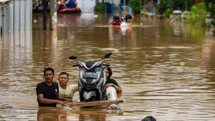Warga membawa bayinya menggunakan ember saat melintasi banjir di Jalan Raya Dayeuhkolot, Kabupaten Bandung, Jawa Barat, Sabtu (6/12/2025). Banjir yang terjadi di Kabupaten Bandung meluas hingga berdampak ke 14 kecamatan dengan volume air yang mengalami kenaikan 10cm hingga 50cm sehingga membuat Pemerintah Kabupaten Bandung menetapkan status tanggap darurat bencana banjir serta longsor dari 6 Desember hingga 19 Desember mendatang. ANTARA FOTO/Novrian Arbi/foc.