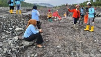 Petugas kepolisian dan warga memantau area Sungai Regoyo setelah jembatan tertutup material banjir lahar pascahujan deras di kawasan Semeru. (Foto: Nur Hadi Wicaksono/detikjatim)