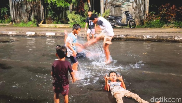 Genangan air di Jalan Gajah Mada, Tarakan dimanfaatkan anak-anak jadi area bermain. (Oktavian Balang/detikKalimantan)