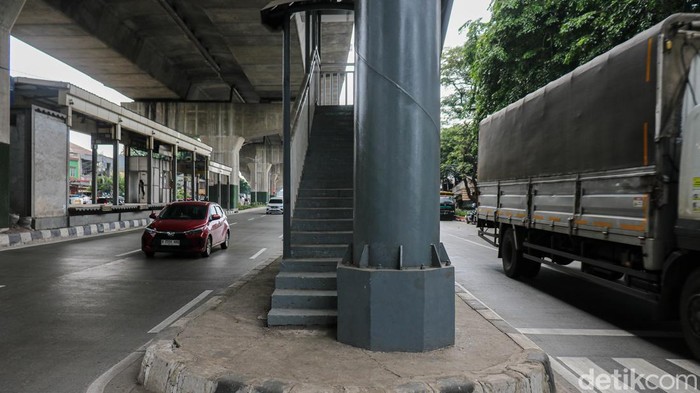 Pejalan kaki melintas di JPO Tipar Cakung, Jakarta, Sabtu (6/12/2025), yang ujungnya berada tepat di tengah Jalan Raya Bekasi sehingga membuat penyeberang harus lebih waspada.
