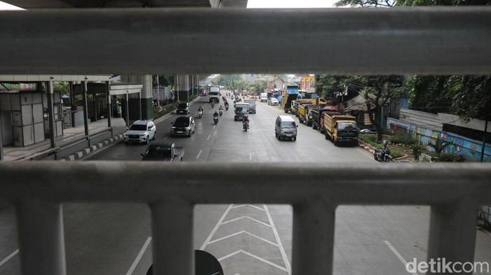 Pejalan kaki melintas di JPO Tipar Cakung, Jakarta, Sabtu (6/12/2025), yang ujungnya berada tepat di tengah Jalan Raya Bekasi sehingga membuat penyeberang harus lebih waspada.