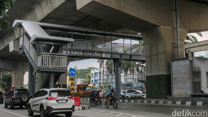 Pejalan kaki melintas di JPO Tipar Cakung, Jakarta, Sabtu (6/12/2025), yang ujungnya berada tepat di tengah Jalan Raya Bekasi sehingga membuat penyeberang harus lebih waspada.