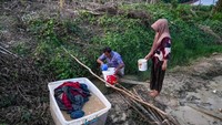 Sejumlah warga menggunakan air parit untuk mencuci pakaian di Rantau, Kabupaten Aceh Tamiang, Aceh, Jumat (5/12/2025). ANTARA FOTO/Erlangga Bregas Prakoso
