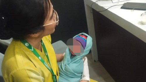 Seorang tenaga medis RS Dedari Kota Kupang saat menggendong bayi laki-laki yang ditemukan di TPU TDM IV, Kelurahan TDM, Kecamatan Oebobo, Kota Kupang, NTT, Sabtu (6/12/2025).