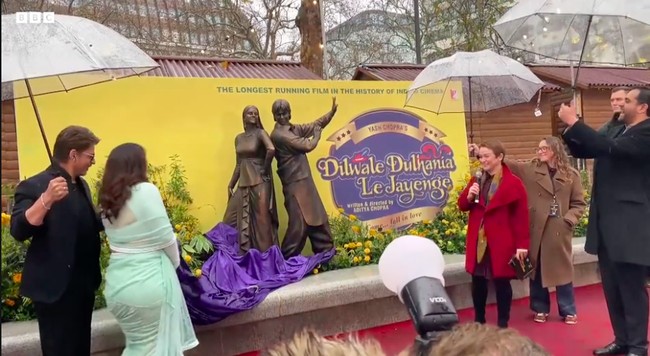 Momen ini mencetak sejarah karena menjadikan ‘DDLJ’ film India pertama yang menerima pengakuan sekaligus bagian dari rangkaian patung Scenes in the Square. Patung Kajol-Shah Rukh Khan bersanding dengan karakter dalam film-film terkenal lain, seperti Harry Potter, Mary Poppins, Paddington, dan Singin in the Rain. Foto: Dok. BBC