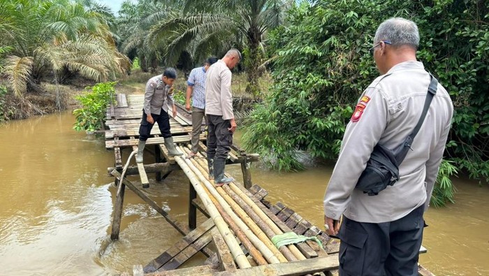 Warga dan Polres Mempawah memperbaiki jembatan utama menuju sekolah di Desa Ansiap. (Dok. Humas Polres Mempawah)