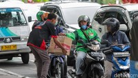 Relawan komunitas motor berjalan di antara kendaraan untuk menghimpun donasi dari pengguna jalan. Penggalangan ini menjadi penting di tengah banyaknya wilayah Sumatera yang masih terisolasi akibat bencana.