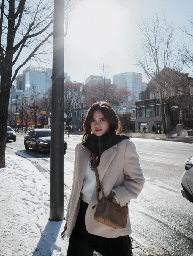 Pose di jalanan bersalju, Audi memadukan dalaman putih dengan celana panjang hitam dan blazer coklat. Syal hitam tampak dililitkan di lehernya sebagai pelengkap. Foto: Instagram/@audimarissa