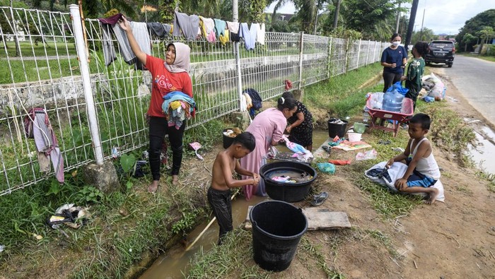Warga mencuci baju dan mandi di parit di Tapanuli Tengah, Sumatera Utara, Sabtu (6/12/2025). Setelah sepekan bencana tanah longsor dan banjir, warga setempat masih belum mendapatkan akses air bersih sehingga terpaksa menggunakan air parit untuk kebutuhan MCK mereka. ANTARA FOTO/Muhammad Adimaja/foc.