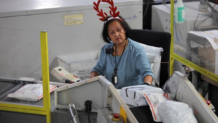A postal worker transports boxes filled with packages at the United States Postal Service (USPS) Processing & Distribution Center in Los Angeles, California, U.S., December 2, 2025. REUTERS/Daniel Cole