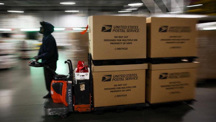 A postal worker transports boxes filled with packages at the United States Postal Service (USPS) Processing & Distribution Center in Los Angeles, California, U.S., December 2, 2025. REUTERS/Daniel Cole