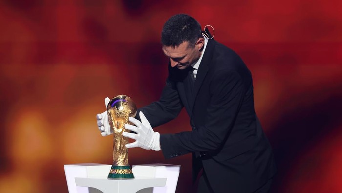 WASHINGTON, DC - DECEMBER 05: Lionel Scaloni, Head Coach of Argentina, places the FIFA World Cup Trophy on a plinth during the FIFA World Cup 2026 Official Draw at John F. Kennedy Center for the Performing Arts on December 05, 2025 in Washington, DC. (Photo by Hector Vivas - FIFA/FIFA via Getty Images)