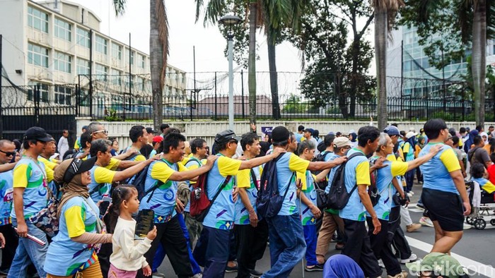 Peserta fun walk, termasuk penyandang disabilitas, mulai bergerak dari area Bundaran HI saat peringatan Hari Disabilitas Internasional (HDI) 2025 di Jakarta, Minggu (7/12). Momen ini menampilkan antusiasme warga yang ikut merayakan semangat inklusivitas.