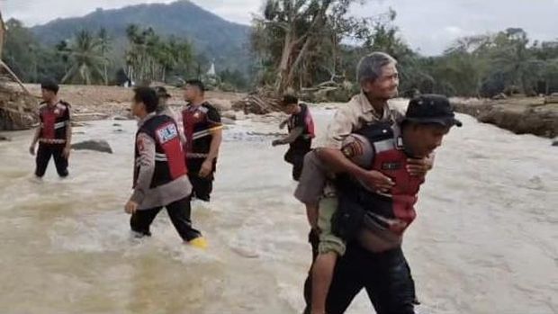 Polisi gendong lansia usai jembatan darurat terputus di Agam (Mei Amelia/detikcom) Polisi gendong lansia usai jembatan darurat terputus di Agam (Mei Amelia/detikcom)