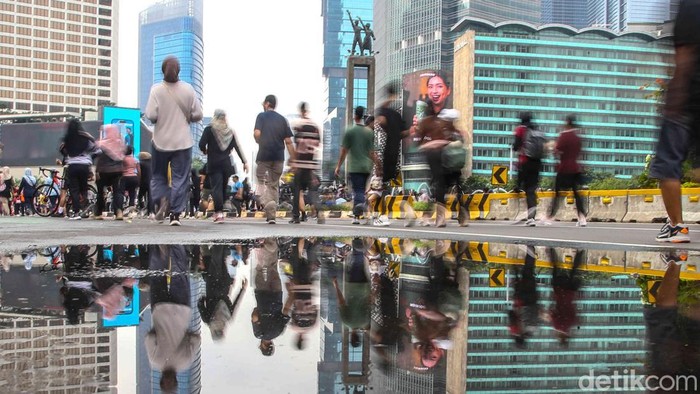 Warga memadati area Bundaran HI saat Car Free Day, menikmati udara pagi sambil melakukan berbagai aktivitas olahraga, Minggu (7/12/2025). Ruang jalan yang biasanya dipenuhi kendaraan berubah menjadi arena olahraga terbuka.