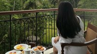 Dengan pemandangan bukit dan pepohonan yang rindang, ini momen Amanda Zahra saat menikmati menu sarapan. Ada kopi, pastry, hingga telur orak-arik. Foto: Instagram/@aamandazahra