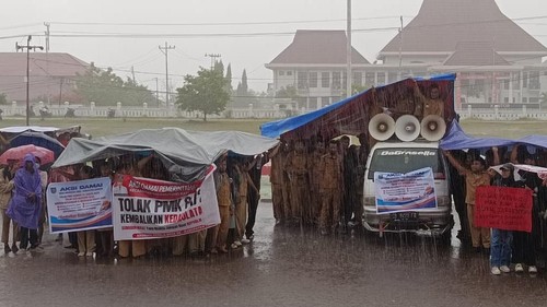 APDESI Kabupaten Lembata rela diguyur hujan deras saat menggelar aksi damai di depan Kantor DPRD dan Kantor Bupati Lembata, NTT, (Foto: Dok. Sandro Balawangak)
