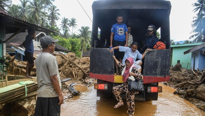 Warga melintasi banjir yang menggenangi permukiman penduduk di Kelurahan Tukka, Kecamatan Tukka,Tapanuli Tengah, Sumatera Utara, Minggu (7/12/2025). Banjir serta kondisi jalan yang dipenuhi endapan tanah mempersulit proses pengiriman bantuan logistik ke wilayah tersebut. ANTARA FOTO/Muhammad Adimaja