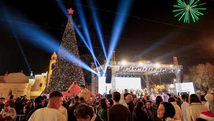Palestinians light up a Christmas tree in Manger Square outside the Church of the Nativity, in Bethlehem, in the Israeli-occupied West Bank, December 6, 2025. REUTERS/Mussa Qawasma