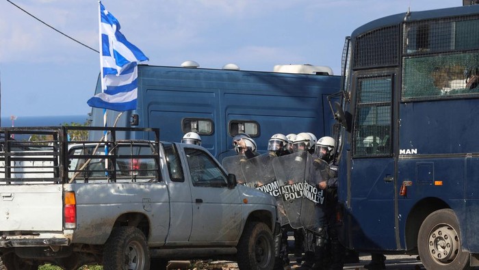 Greek farmers hurl stones amid tear gas at the Heraklion International Airport, in Heraklion, Crete island, Greece, December 8, 2025. REUTERS/Stefanos Rapanis