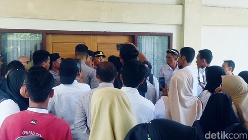 Ratusan guru honorer menggedor pintu DPRD Dompu di tengah rapat paripurna, Senin (8/12/2025).
