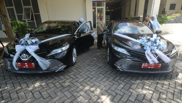 Pasangan pengantin dan keluarga berjalan didekat fasilitas mobil pengantin gratis di Mal Pelayanan Publik (MPP) Boyolali, Jawa Tengah, Senin (8/12/2025). Pemerintah Kabupaten Boyolali memberikan fasilitas mobil pengantin gratis dengan menggunakan mobil dinas Bupati dan Wakil Bupati Boyolali bagi warga Boyolali. ANTARA FOTO/Aloysius Jarot Nugroho