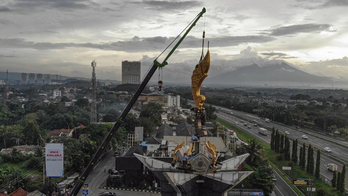 Foto udara pekerja memasang ornamen senjata kujang di Tugu Pancakarsa, Simpang Sentul, Babakanmadang, Kabupaten Bogor, Jawa Barat, Senin (8/12/2025). Pemerintah Kabupaten Bogor memasang ornamen senjata kujang raksasa setinggi 14 meter untuk menghadirkan simbol khas Sunda sebagai upaya pelestarian budaya daerah serta menjadi ikon baru di Kabupaten Bogor. ANTARA FOTO/Yulius Satria Wijaya/nym.