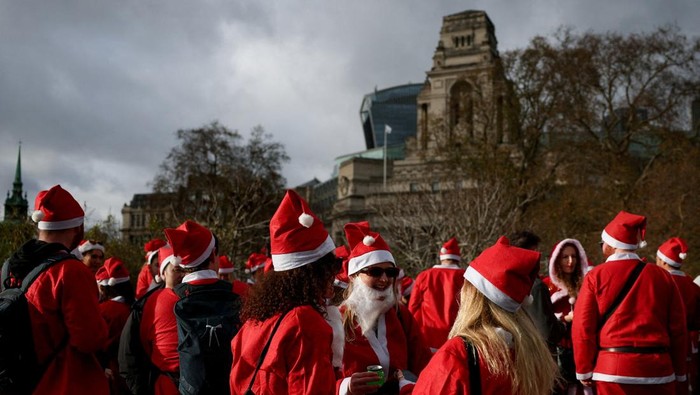 Revellers dressed up as Santa Claus gather near the Tower of London, on the day of the annual SantaCon, a global annual event in which people dress up in Santa-themed costumes and parade around cities to celebrate Christmas, in London, Britain, December 6, 2025. REUTERS/Isabel Infantes      TPX IMAGES OF THE DAY